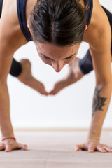 Young brunette woman balance arm-pressing asana