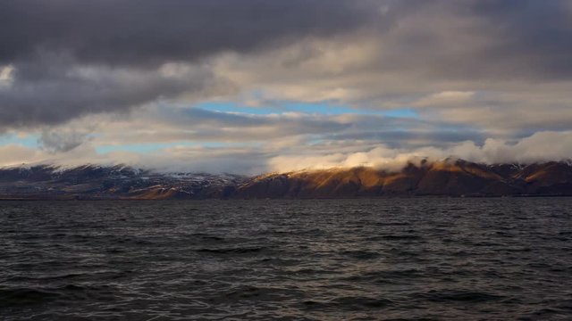 Daytime Timelapse of moving clouds over lake Sevan on background hills.