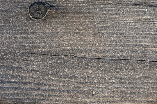Eiskristalle auf einer Holzbank in der Morgensonne