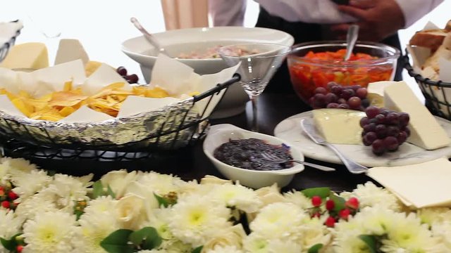 Mesa de quesos en una fiesta de bodas, un mesonero espera a que lleguen los comensales