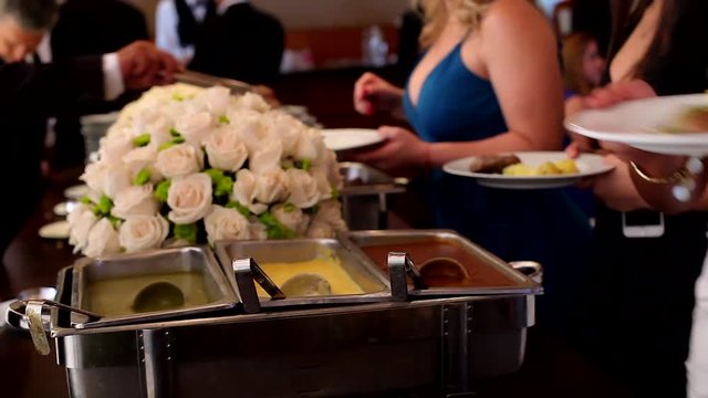 Gente comiendo en un buffet de fiesta de bodas