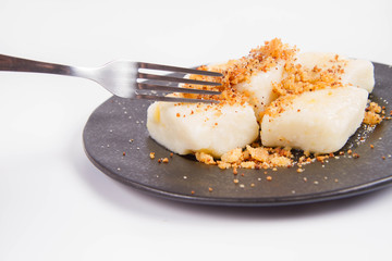 Dumplings with cottage cheese (traditional polish dish called lazy pierogi/ leniwe pierogi) fried with bread crumbs and sprinkled with sugar, eaten with a fork