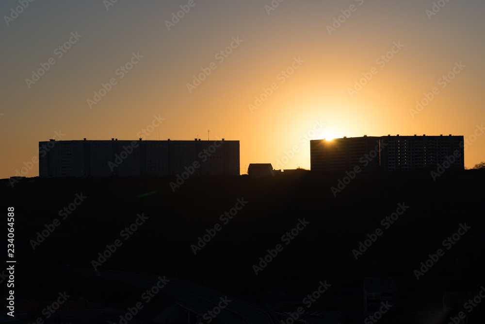 Poster urban landscape with silhouettes of high-rise buildings in the background light of the sunset.