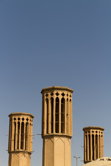 Iconic Badgirs (windtowers) in the mud-brick desert city of Yazd, Iran. An ancient rooftop air conditioning system that captures the wind for cooling the houses below.