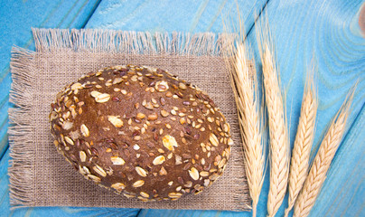 Multi-grain bread rolls on on blue wooden table.