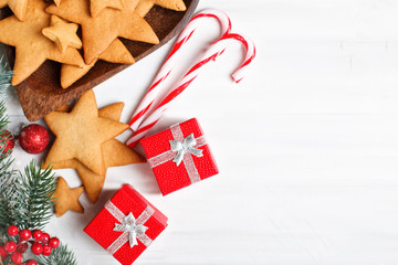 Merry Christmas and happy New year. Cookies, gifts and fir-tree branches on a white wooden table. Selective focus. Christmas background. Horizontal. Background with copy space.