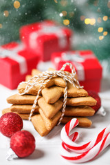 Merry Christmas and happy New year. Cookies, gifts and fir-tree branches on a white wooden table. Selective focus. Christmas background.