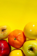 Colorful Fruits Over Yellow Background.  Mandarin, Lemon And Apple Over Yellow Background. Healthy Food Concept.
