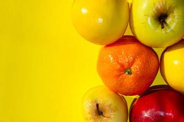 Colorful Fruits Over Yellow Background.  Mandarin, Lemon And Apple Over Yellow Background. Healthy Food Concept.
