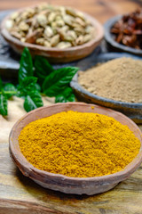 Old clay bowls wirh curry powder seeds close up, spices collection