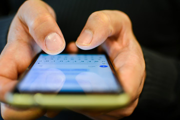 Women's hands use a white screen mobile phone. The hands touch the touch screen with a large aperture.