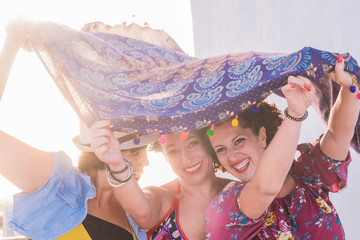 three young women have fun together playing with the wind and laughing a lot having a lot of fun -...