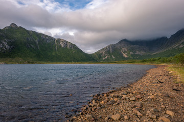 Rocky shore with green mountain peaks