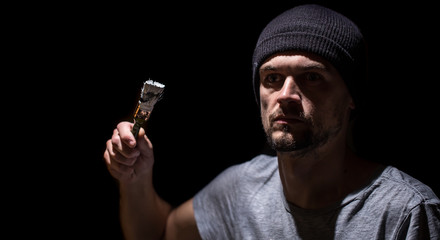 man paints a brush with white paint on a black background, industrial concept.