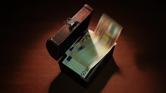 Secret profit, shadow economy. 50 Euro. Money falls in the ancient chest. 50 Euro banknotes. Artistic dark background. If you buy this footage, I will be very grateful to you!