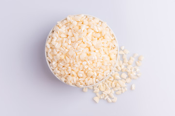 Dry uncooked white corn ingredient for Brazilian dessert sweet canjica / mungunza, white background, isolated, soft light. Festa Junina Party Brazilian Culture Concept Image.