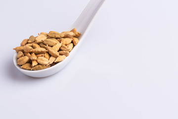 Dry Cardamom pod in a stone mortar, isolated on white background, latin term Elettaria cardamomum,  with copy space, angle view, soft light. 