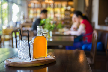 Glass bottle of ice tea on table in vintage style restaurant