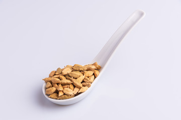 Dry Cardamom pod in a stone mortar, isolated on white background, latin term Elettaria cardamomum,  with copy space, angle view, soft light. 