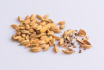 Dry Cardamom pod in a stone mortar, isolated on white background, latin term Elettaria cardamomum,  with copy space, angle view, soft light. 
