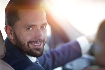 Close-up of a businessman sitting at the wheel of a car