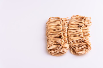 Dry uncooked whole instant noodles isolated in white background, top view, copy space, soft light, wholegrain pasta