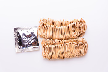 Dry uncooked whole instant noodles isolated in white background, top view, copy space, soft light, wholegrain pasta