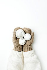 Christmas balls decoration in female hands in knitted mittens on white background. Flat lay, top view Christmas / New Year / Winter festive composition.