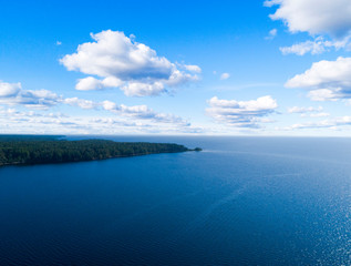 Fototapeta premium Aerial view of seashore with beach, lagoons. Coastline with sand and water. Landscape. Aerial photography. Birdseye. Sky, clouds. Stunning sky clouds. Sky landscape.