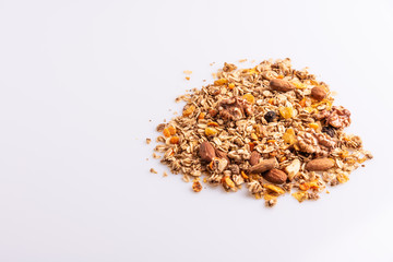 Granola or muesli with nuts and rasins on a white background, angle view, copy space, soft light