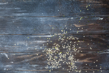 Dark wooden background with golden confetti