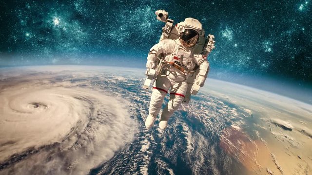 Astronaut in outer space against the backdrop of the planet earth. Typhoon over planet Earth. Elements of this image furnished by NASA.