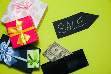 Black Friday concept photo with an arrow. Present boxes for Birthday parties. Sale and discount. Christmas shopping ideas. Special offer. Copy space. Cheap prices. Dollars money in wallet.