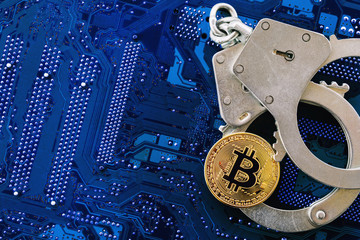 Bitcoin and handcuffs on computer chip with copy space, top view. Concept of prohibition of mining