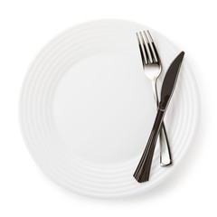 Fork and knife on empty white ceramic plate, isolated