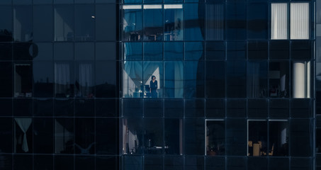 Aerial Shot from the Outside Into Office Building with Businessman Looking out of the Window. Beautiful Shot of The Financial District Skyscrapers. 