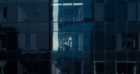 Aerial View Shot: From Outside into Office Building with Businessman Working and Looking out of the Window. Shot of The Financial Business District Skyscrapers. 