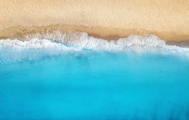 Strand und Wellen aus der Draufsicht. Türkisfarbener Wasserhintergrund aus der Draufsicht. Sommermeerblick aus der Luft. Ansicht von oben von der Drohne. Reisekonzept und Idee