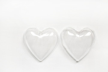 halves of empty plastic hearts on a white background