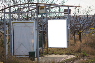 Vertical billboard mockup on bus stop in village