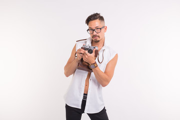 Technologies, photographing and people concept - handsome young man with retro camera over white...