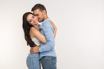 Handsome man hugging his girlfriend on white background with copy space