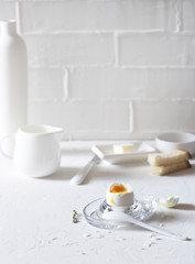 Traditional morning breakfast, boiled eggs, butter, bread, milk, on a white background, modern style