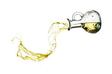 Olive oil pouring from glass bottle isolated against white background