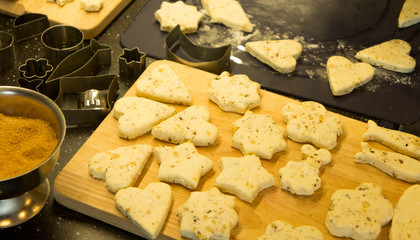 The process of baking cookies at home, close-up on the cookie cutter on the dough and rolling pin on a wooden Board