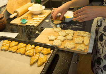 The process of baking cookies at home, close-up on the cookie cutter on the dough and rolling pin on a wooden Board