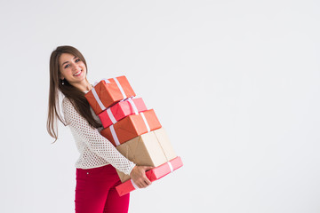 Christmas, holidays and presents concept - woman holding a lot of gifts on white background with copy space