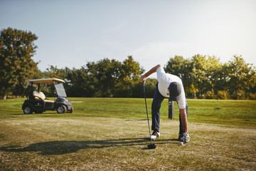 Senior man putting his ball on a golf tee