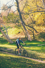 Fototapeta premium The girl rides a bike in the autumn park.