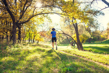Fototapeta premium The girl runs through the autumn park.